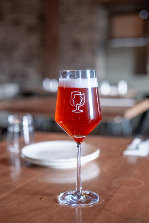 Harmony Berliner Weisse, a red-hued passion fruit and raspberry tart beer, in a stemmed glass