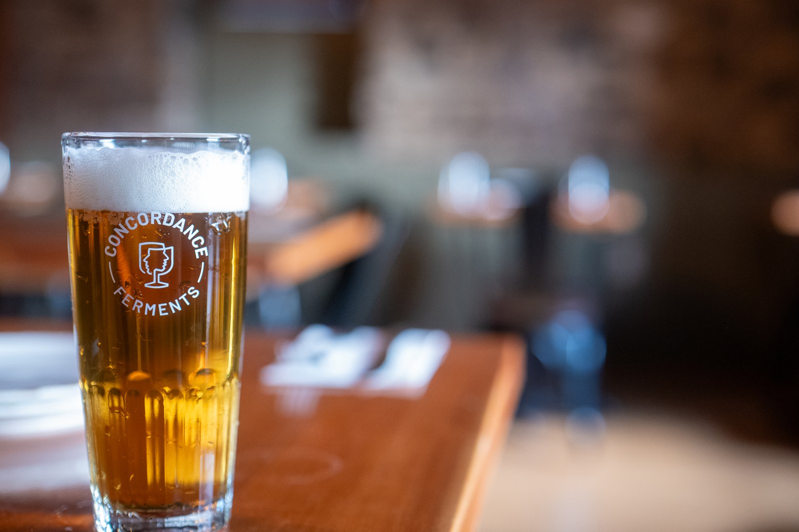 A fresh pour of Continental Pils on a wood table in the dining room